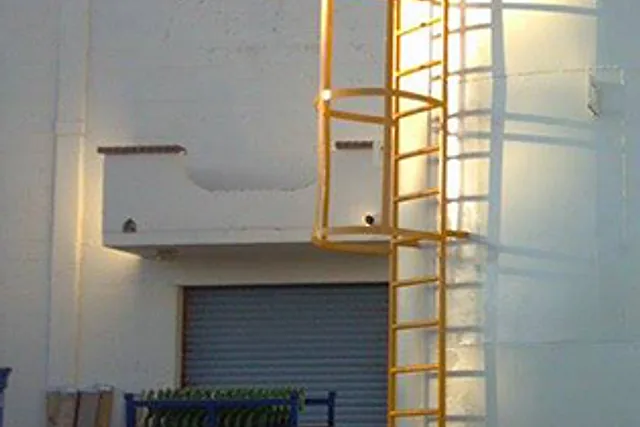Tanque metálico de almacenamiento con escalera de gato en la planta Ansell